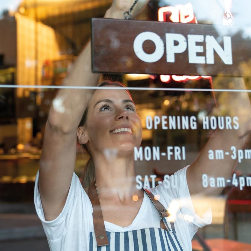 McLain-Insurance-Business-Insurance McLain Insurance Agency | Chesterfield, SC | young business owner turning open sign on door, business insurance